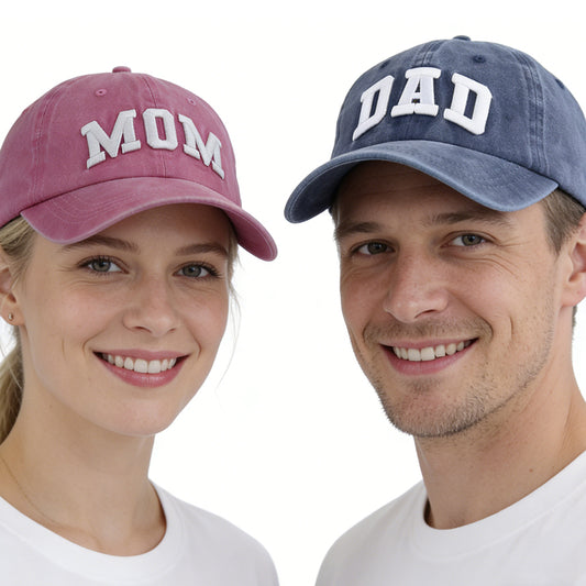 Two people wearing 'MOM' and 'DAD' hats on a white background