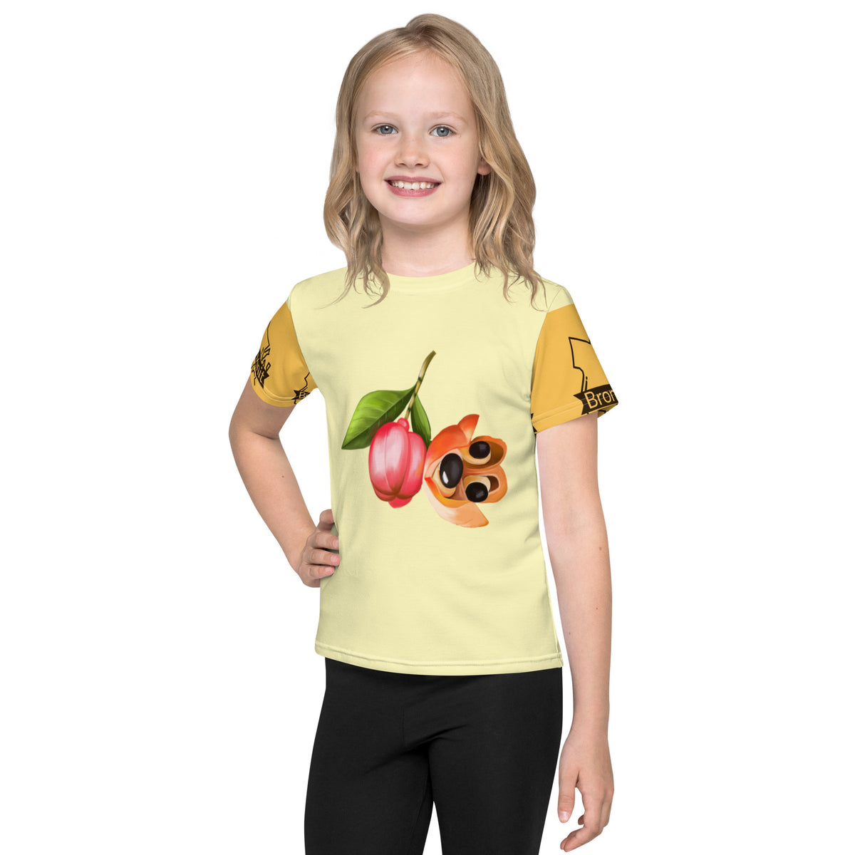 A child wearing a yellow t-shirt with a graphic design featuring an ackee fruit and two other fruits on the front.