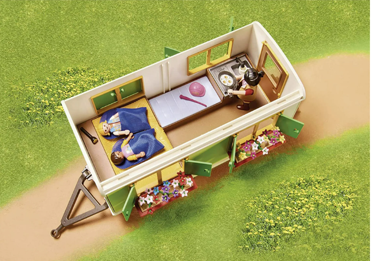 Toy playset with a small house, people, and furniture on a grassy background