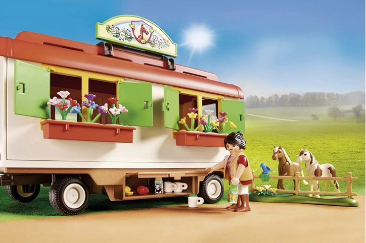 Toy camper with a child and animals in a pastoral setting